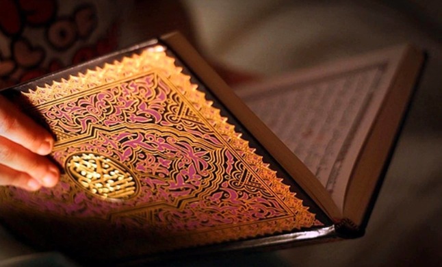 An open, illuminated copy of the Holy Qur'an